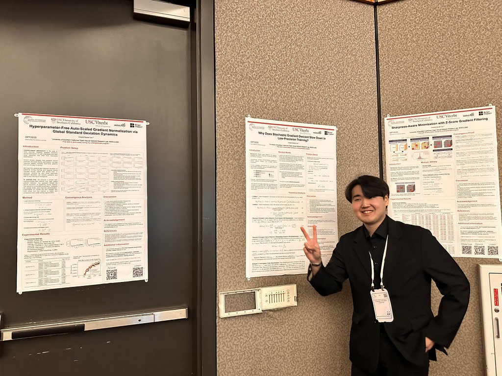Vincent-Daniel Yun beside workshop posters at NeurIPS 2025